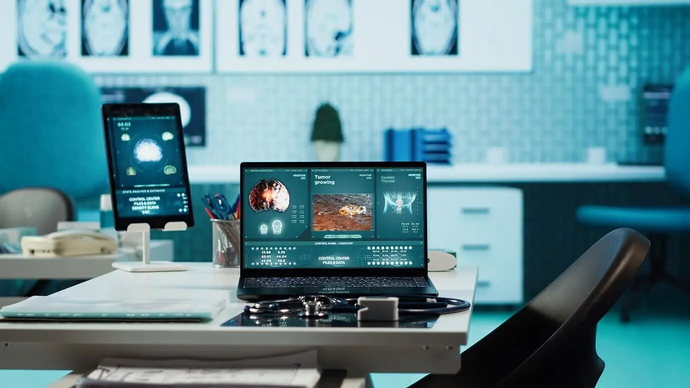 Пустой медицинский кабинет частной клиники с ноутбуком и оборудованием для диагностики.