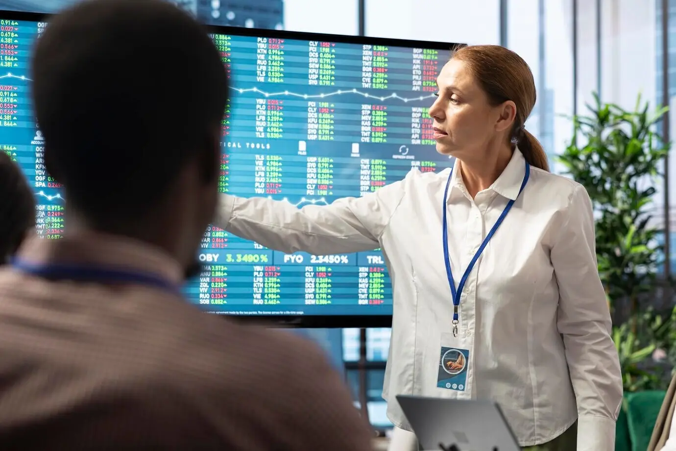 Разнообразная команда руководителей оценивает бюджетные отчеты на интерактивной доске.