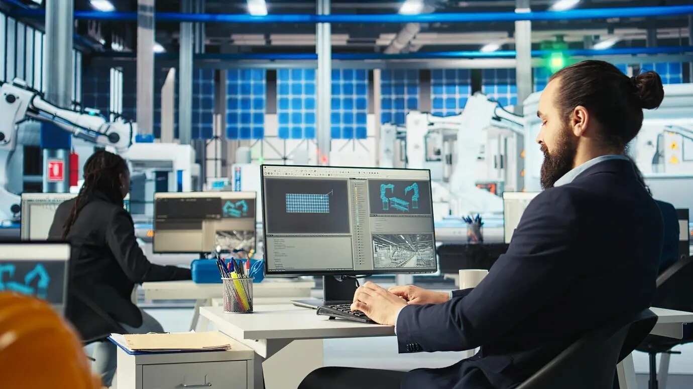 Эксперт фотовольтаического завода проверяет на компьютере оборудование солнечной электростанции.